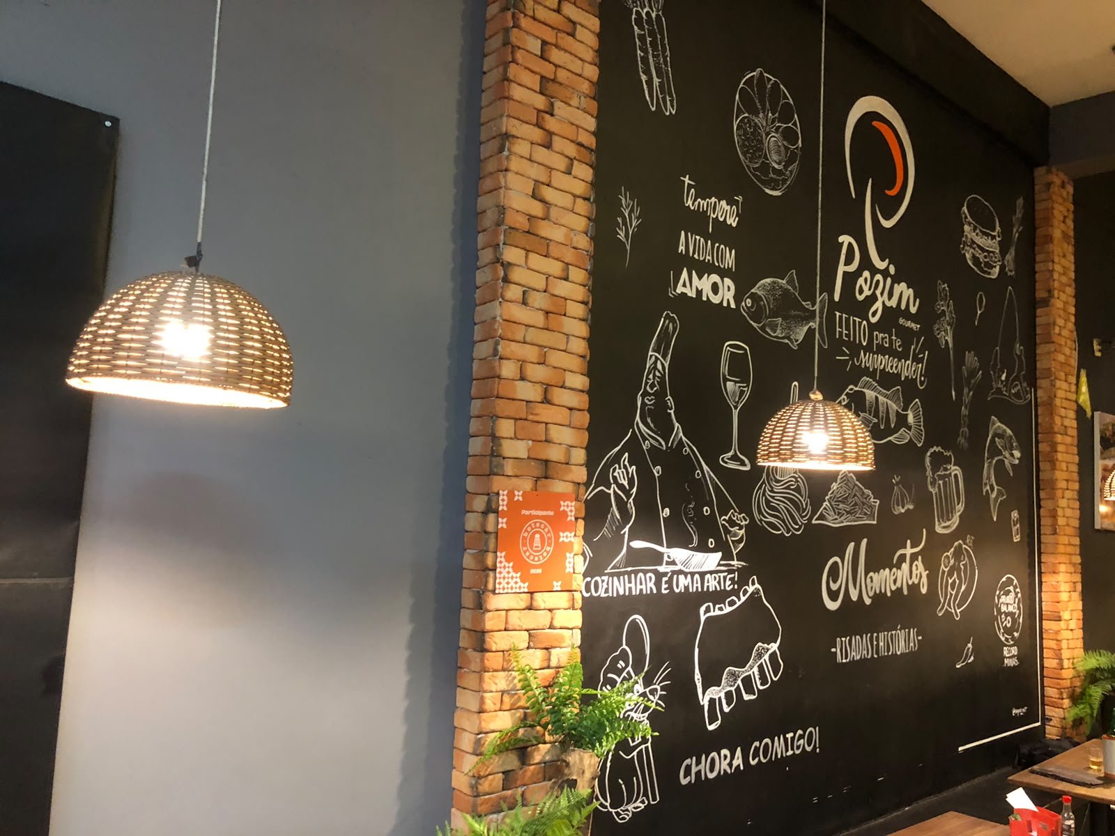Parede do salão do Pozim Gourmet com a marca desenhada a giz